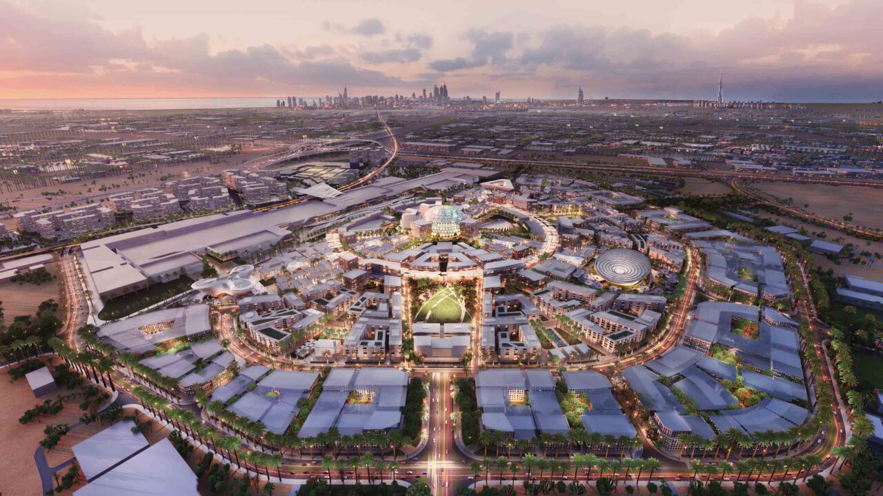 An aerial shot of a brightly lit Expo 2020 Dubai during sunset