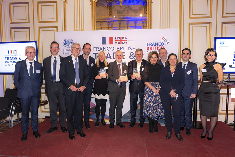 Steve Dering at Franco British Chamber Awards surrounded by a mixed group of other recipients, all well dressed in suits and dresses.