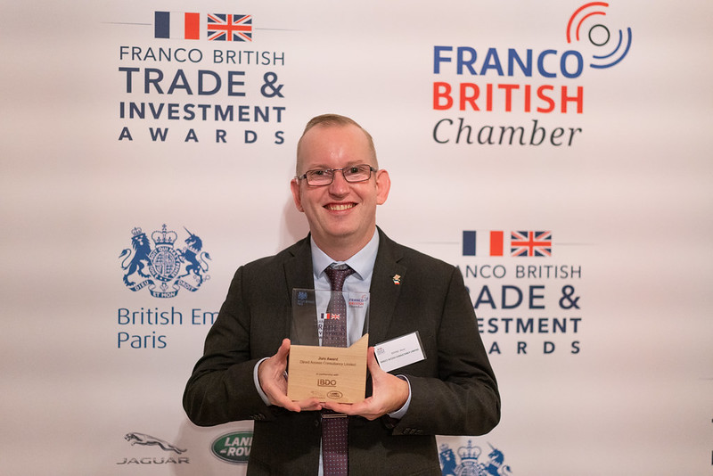 Steve Dering at Franco British Chamber Awards carrying an awards statue and smiling.