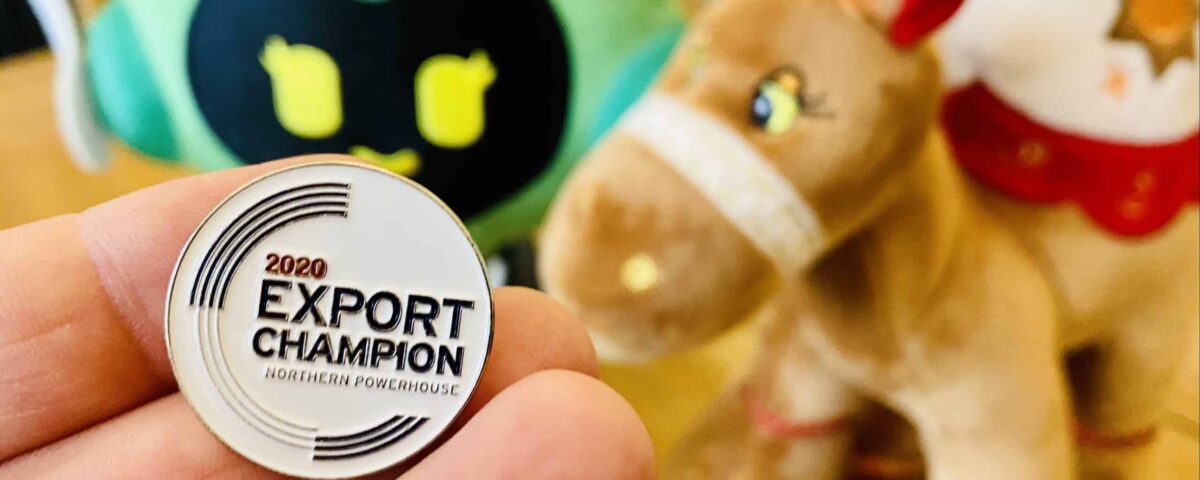 A close up of a hand holding a 2020 Export Champion Northern Powerhouse badge.