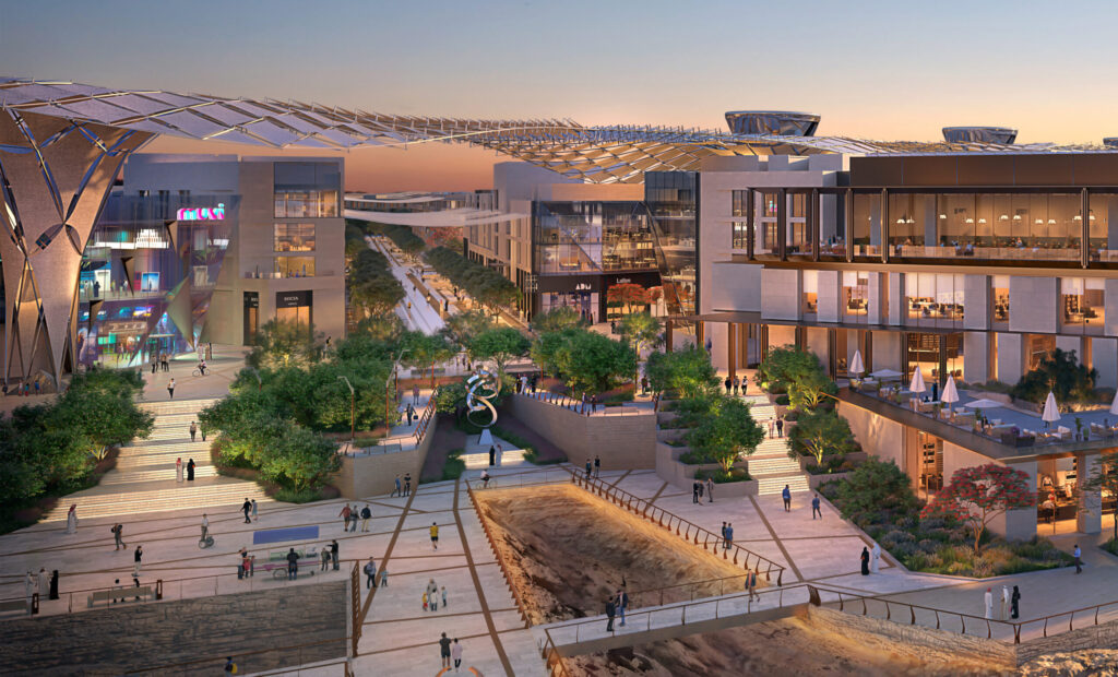 A concept photo of the MiSK Foundation proposed design, showing a town centre with various offices and shops at sunset. Nature is implemented in the design, with trees implemented across the site.