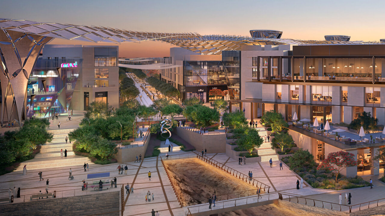 A concept photo of the MiSK Foundation proposed design, showing a town centre with various offices and shops at sunset. Nature is implemented in the design, with trees implemented across the site.
