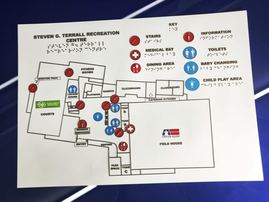 A tactile map of the Steven G. Terrall recreation centre featuring a braille field map of the site and a braille key of the key areas, including child play area, dining area, medical bay and toilets.