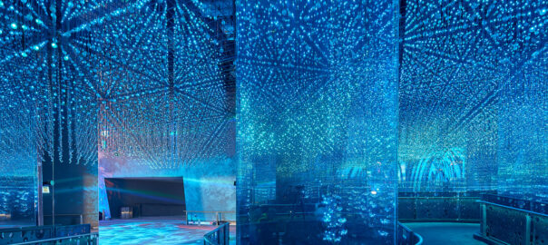 General view of the Under the Sea exhibition as part of Terra The Sustainability pavilion at Expo 2020 Dubai. A large room with exhibits lit by sea blue fairy lights designed to mimic underwater views illuminates the exhibits.