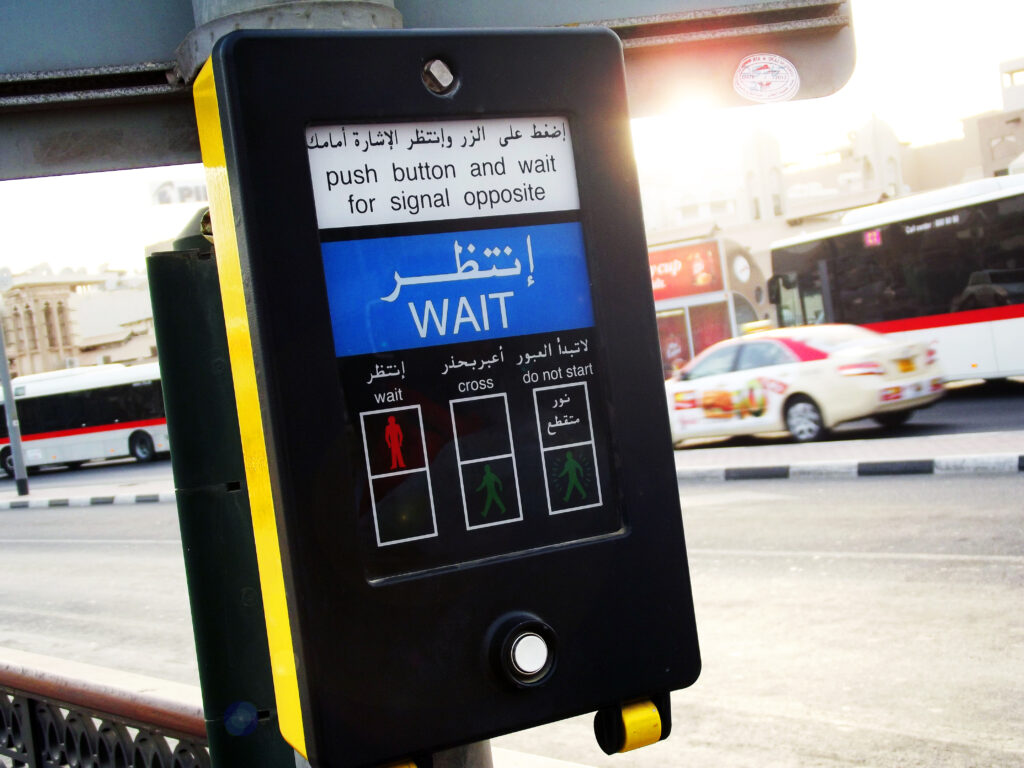 A close up photograph of a traffic light device on a pedestrian crossing on a road in Dubai.