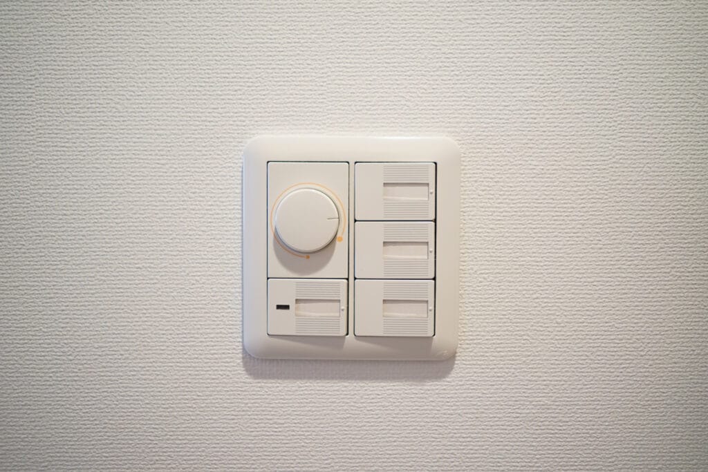 A close up of a white light switch with an adjustable light diming switch.