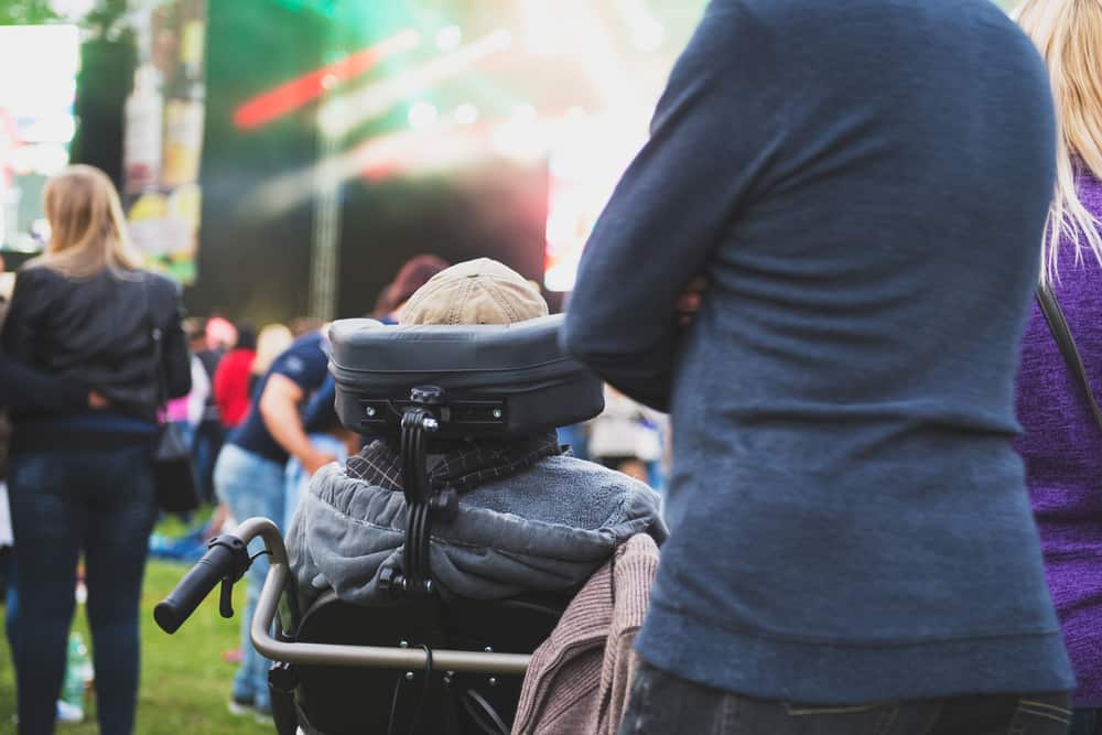 Wheelchair user watches a band perform at a music festival