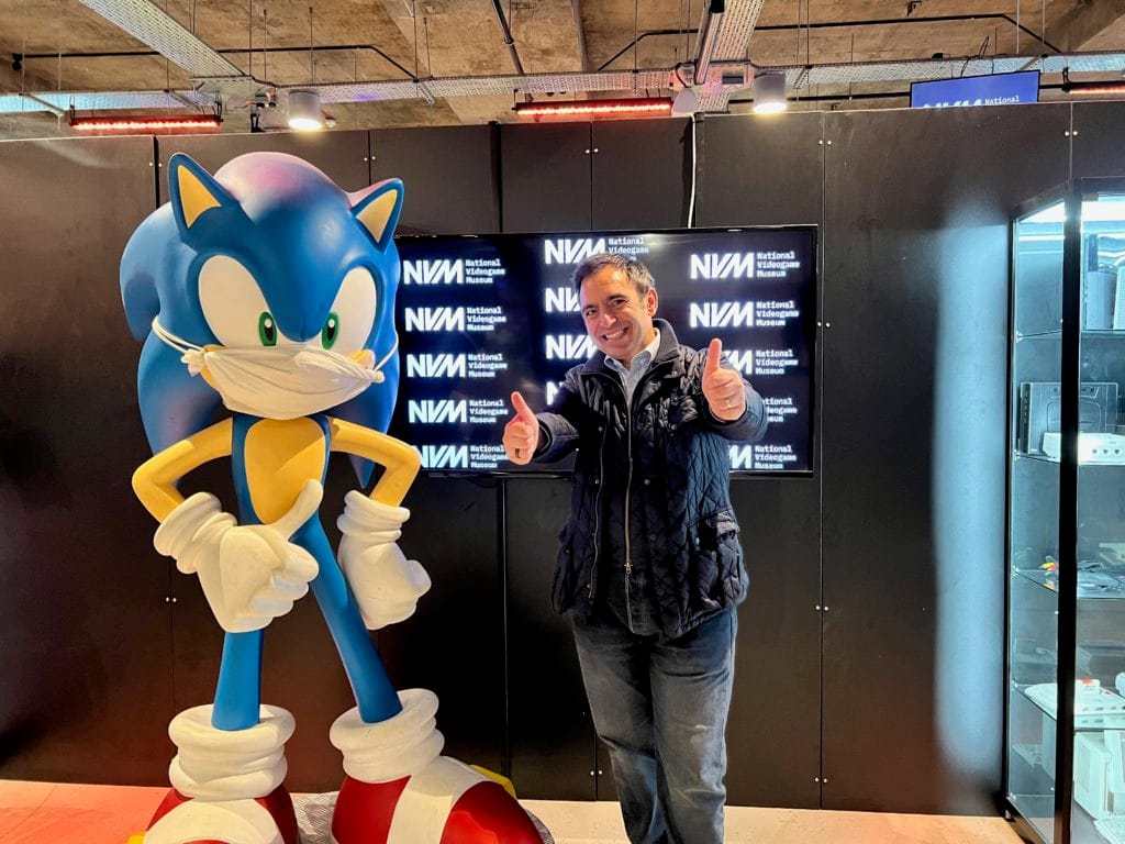 Steven Mifsud doing a thumbs up next to a bust of Sonic the Hedgehog, also holding doing a thumbs up.