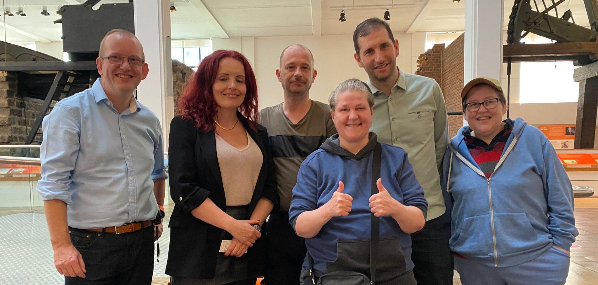 A diverse group of disabled people at a consultation event at the Science Museum in London pose for a selfie together