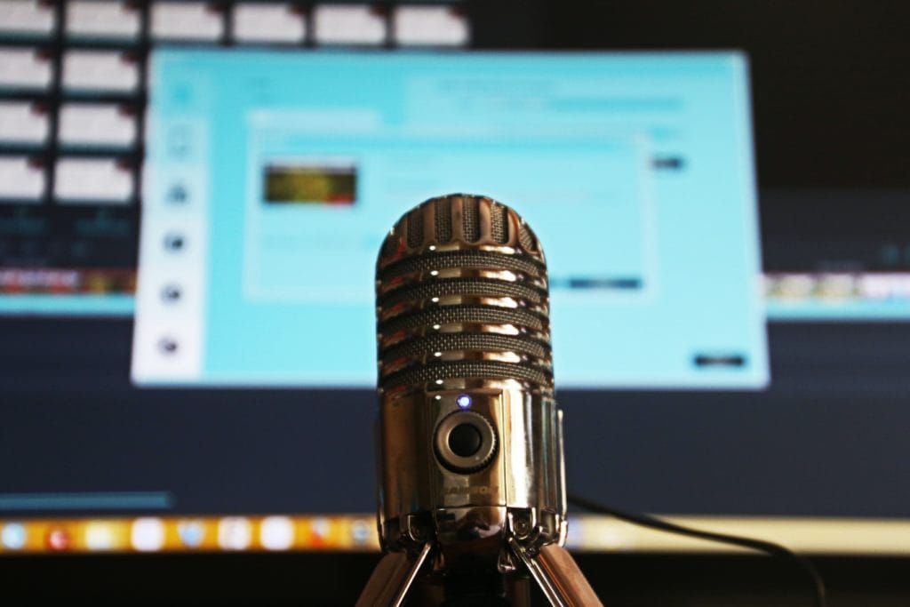 Microphone for podcasting with a computer monitor directly behind it