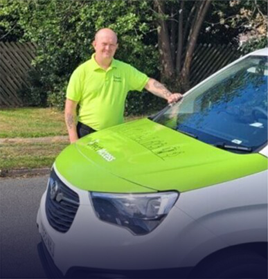 A photograph of Direct Access field service engineer Andy Lomas posing next to the Direct Access van featuring our logo and signature green colouring.