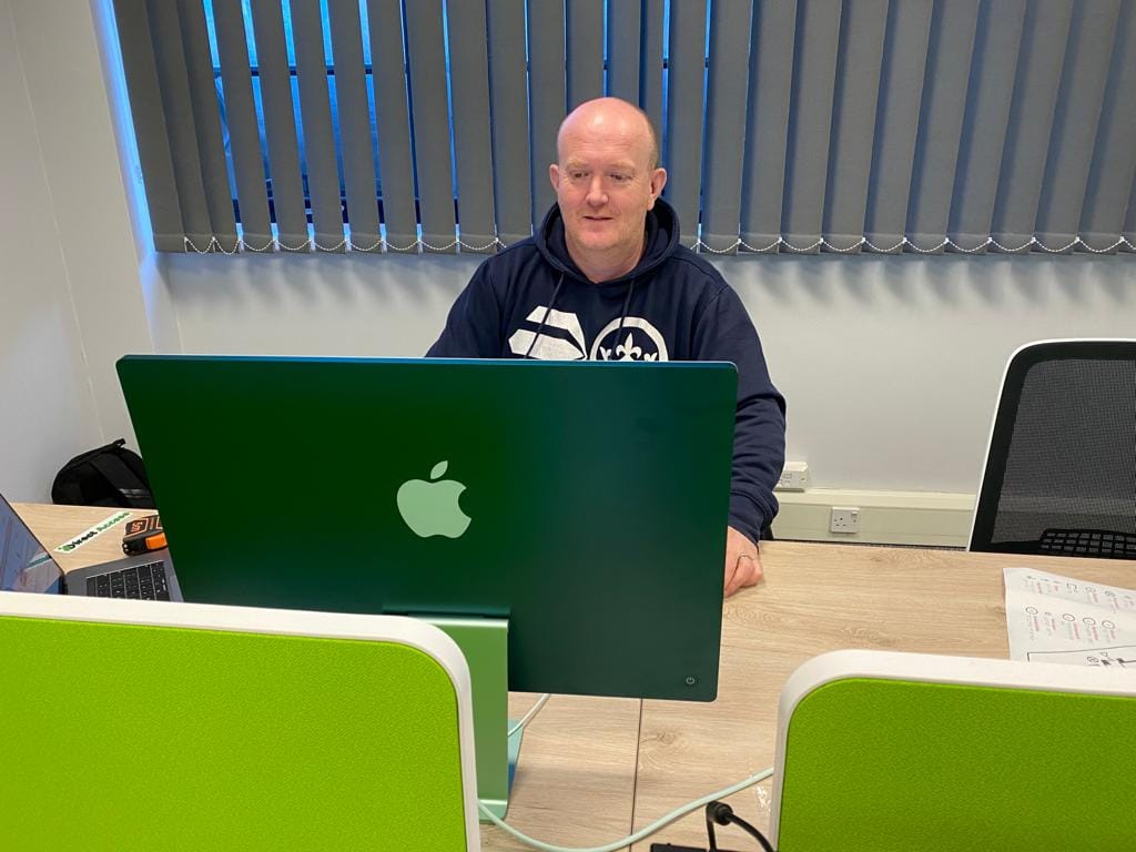 A photo of Direct Access field service engineer Andy Lomas doing work on a Mac computer.