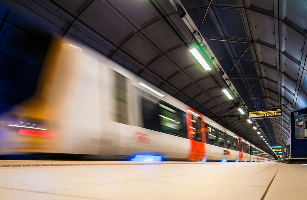 A photo of a train arriving at an underground station. The photo is shot with a low shutter speed giving it a blurred effect.
