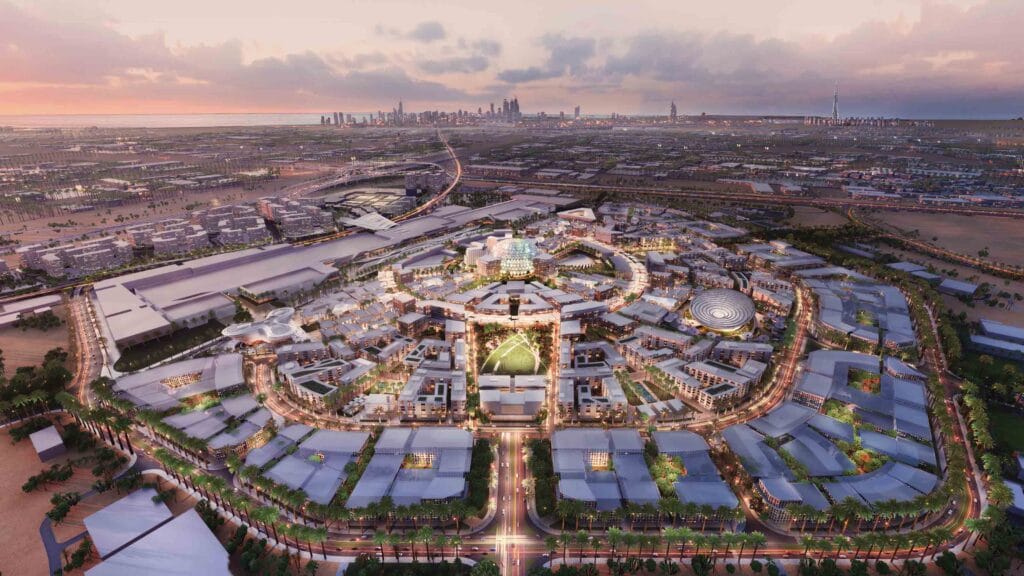 An aerial shot of a brightly lit Expo 2020 Dubai during sunset.
