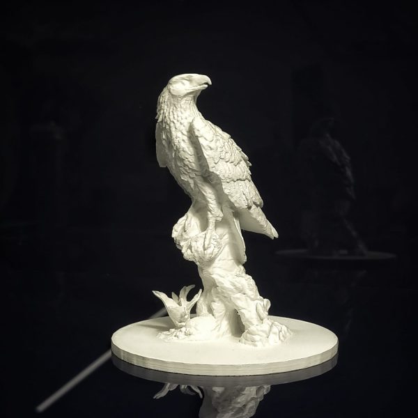 WhatsApp Image 2023-08-31 at 15.36.10 A crisp white, 3D, tactile bust of a bald eagle on a black table.