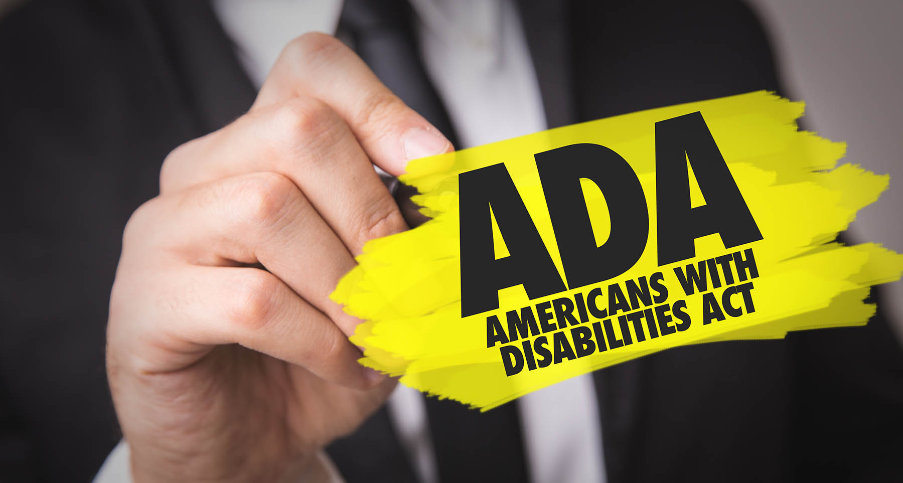 Person with pen and graphic reading ADA - Americans With Disabilities Act