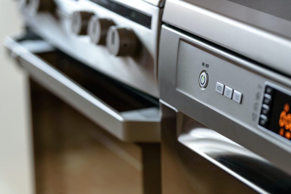 A close up shot of a button board on a modern stainless steel oven.