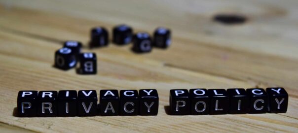 Privacy Policy spelt out in small toy cubes on a brown wooden table.