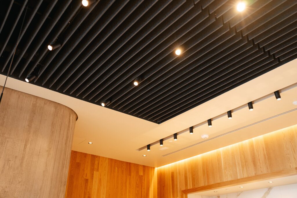 A photograph of the ceiling in the new inclusive Starbucks store in Washington. A warm orange glow permeates from the lights on the black ceiling.