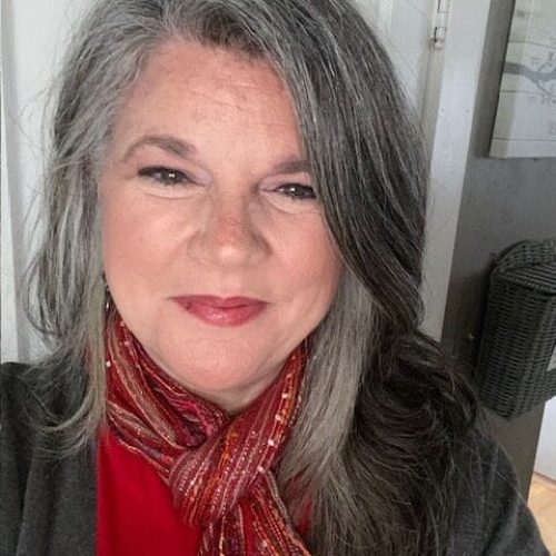 A selfie photograph of Jennifer Ford, a middle aged woman with grey hair and Direct Access consultant. She is smiling towards the lens