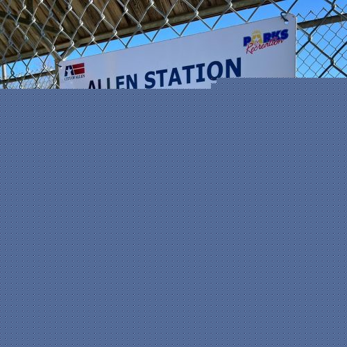A mesh fence with a sign on it that lists the rules of Allen Station Park.